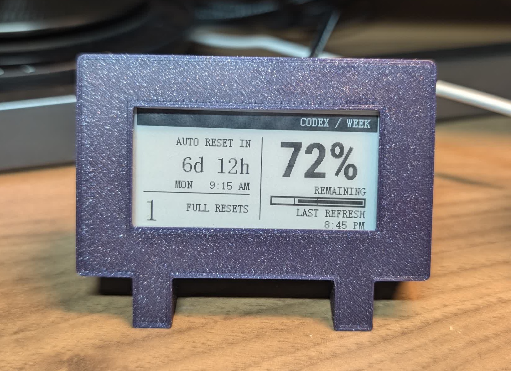 A closer view of the finished purple e-paper display beneath the monitor.