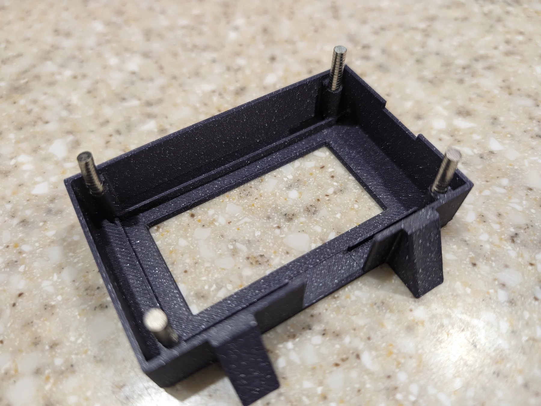 Four magnets being installed into the corners of the V4 frame